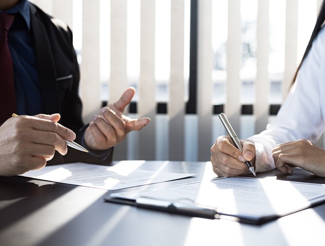 The home insurance salesman and the customer are signing an insurance agreement with their insurance company, accepting the terms and benefits. Home and real estate insurance concept.