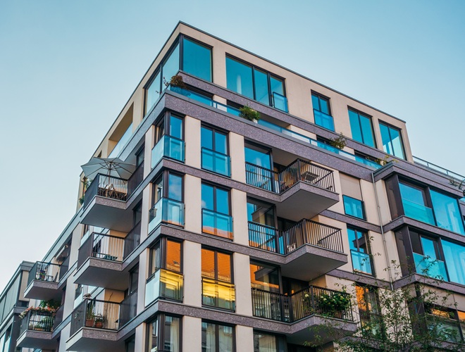 modern corner apartment complex with blue colored windows and light leaks