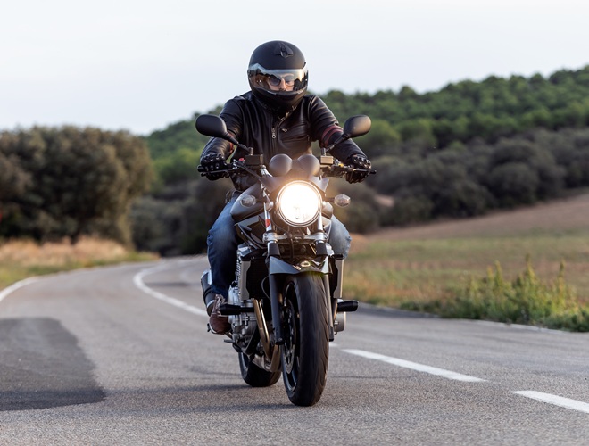 Shot of young man biker having fun driving the empty highway on a motorcycle tour journey.